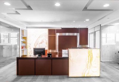 Professional reception desk with dark wood finishes and a white marble feature panel.