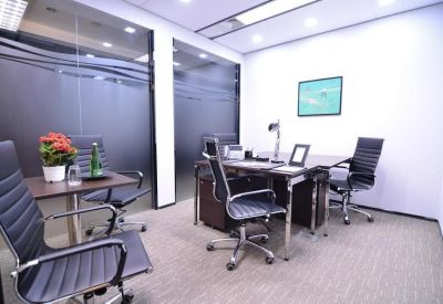 Modern two-person office suite with glass walls and a corner desk arrangement.