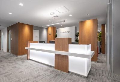 Modern reception desk with bright integrated lighting and warm wood paneling.