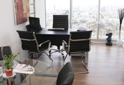 Private office suite with dark wood furniture and expansive city views through floor-to-ceiling windows.