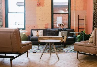 Relaxed lounge area with leather armchairs, a coffee table, and exposed brick walls.