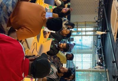 Long communal table in a vibrant coworking space with professionals working on laptops.