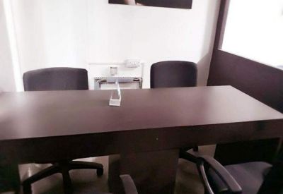 Dark wood four-person meeting table with high-back black chairs.
