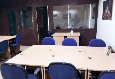 Large six-person meeting table with blue chairs and a glass partition wall.