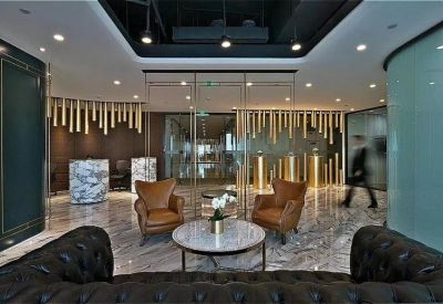 Elegant reception lobby with marble floors, leather armchairs, and decorative gold partitions.