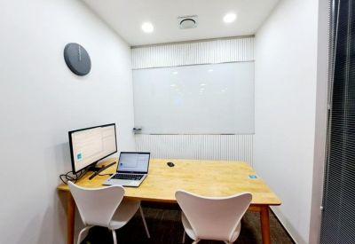 Compact meeting room with a whiteboard and a wooden table for two.