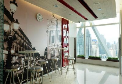 Social breakout area with high stools and a Parisian-themed wall mural.