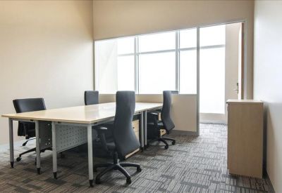 Bright internal office suite with two workstations and a glass partition.