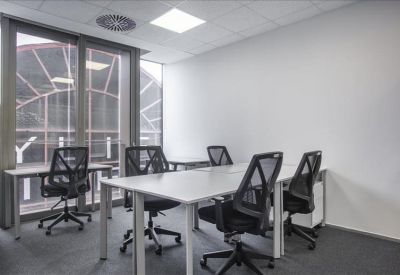 Bright multi-desk office suite with floor-to-ceiling windows.
