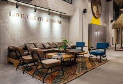 Reception lounge with mid-century modern chairs and motivational wall text.