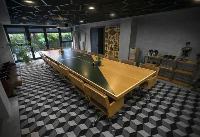 Conference room with a large geometric-patterned table and honeycomb ceiling.