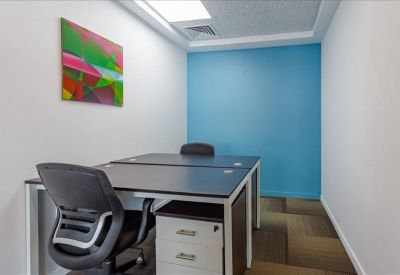 Compact two-person office with a bright blue accent wall and modern artwork.