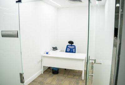 Private office suite with a white desk and a blue mesh ergonomic chair.