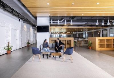 Bright reception area featuring a long white desk and natural wood wall panels.