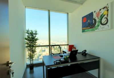 Private office suite with a dark wood desk, potted plant, and vibrant abstract wall art.