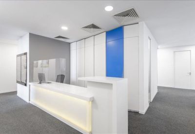 Sleek white reception desk with integrated lighting and blue wall detailing.