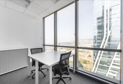 Bright corner office with floor-to-ceiling windows and city views.