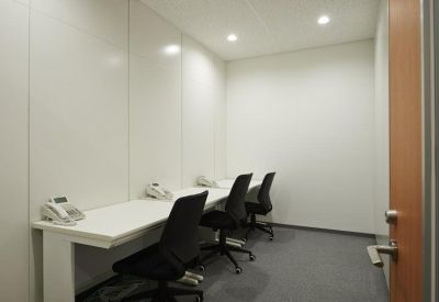 Private internal three-person office with white desks and black ergonomic chairs.