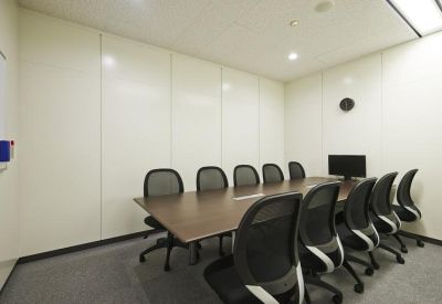 Professional meeting room featuring a dark wood conference table and ten black mesh chairs.