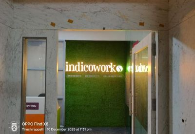 A branded reception entrance with a vibrant green moss wall at Indicowork.