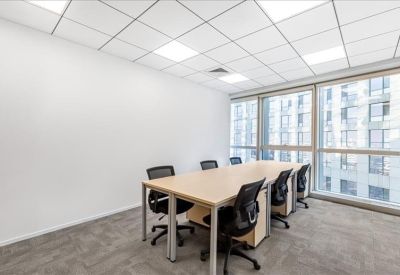 Spacious six-person boardroom with light wood table and modern ergonomic chairs.