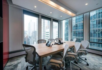 Professional meeting room featuring a wooden conference table and ergonomic mesh chairs.