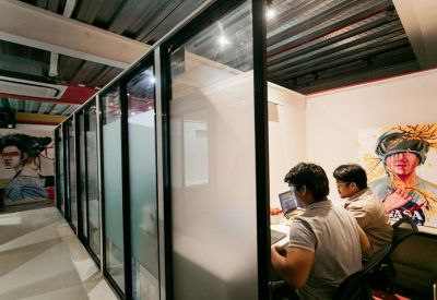 Private office pods with glass partitions and vibrant character artwork.