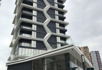 Street-level view of the building's glass entrance and dark grey lower facade.