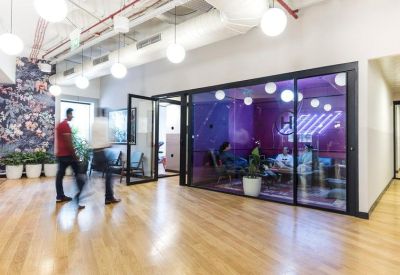 Modern hallway featuring a meeting room with purple tinted glass walls.