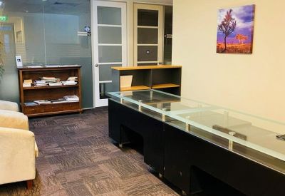 Communal waiting area with glass display cases and comfortable armchairs.