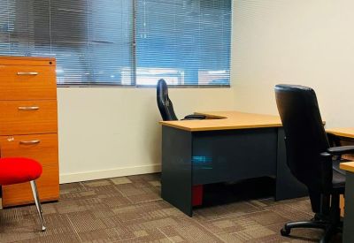 Internal office space with workstations and a tall wooden filing cabinet.