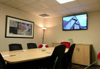 Spacious meeting room featuring a large table and wall-mounted television.