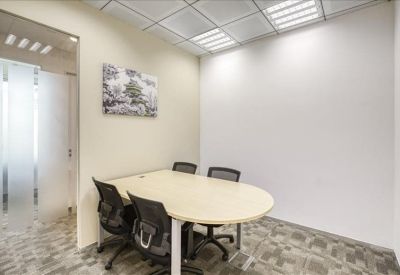 Four-person meeting room with an oval table and framed wall art.