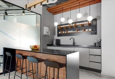 Modern kitchen and breakout area with wooden island and globe pendant lights.
