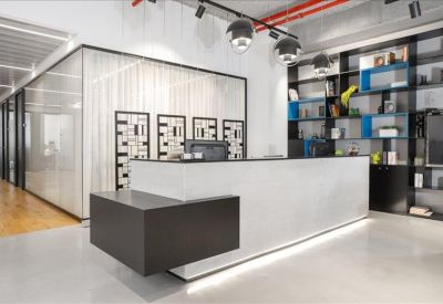 Minimalist white reception desk with integrated lighting and black shelving unit.