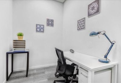 Bright private office suite with white desk and patterned wall art.