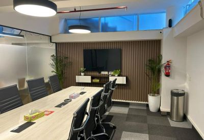 Meeting room at GC Towers with wood-paneled walls, large monitor, and potted plants.