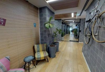 Hallway featuring gray tiled walls, a bicycle mount, and comfortable accent chairs.