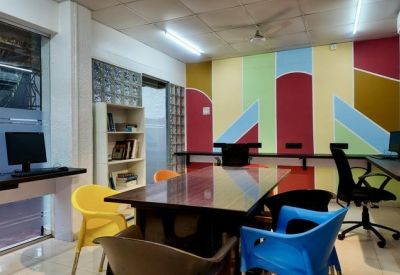 Meeting room with a large wooden table and a vibrant, colorful geometric feature wall.