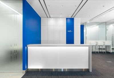 Bright reception area featuring a white desk and a vibrant blue accent wall.
