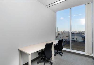 Private office space for two with a long desk and large windows overlooking the city.
