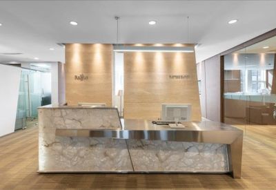 Polished stone reception desk with warm wood paneling behind.