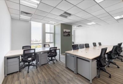 Spacious open-plan coworking area with wooden flooring.