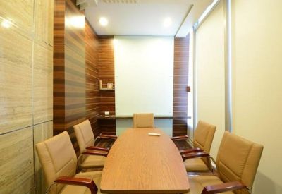 Professional small meeting room with a wooden table and leather chairs.