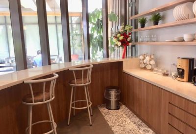 Modern break area with a breakfast bar, high stools, and a coffee station.