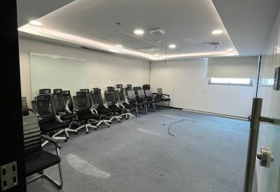 Empty meeting room with modern black chairs and a whiteboard wall.