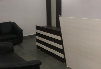 Reception area featuring a dark wood striped desk and black leather sofas.
