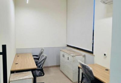 Compact three-person office suite with light wood desks.