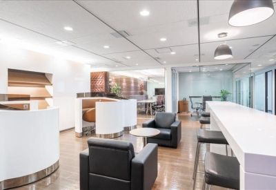 Spacious communal lounge featuring curved white seating booths, black armchairs, and a long white breakfast bar.