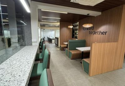 Cozy breakout area featuring green upholstered booths and a wooden wall with the text Forward Together.